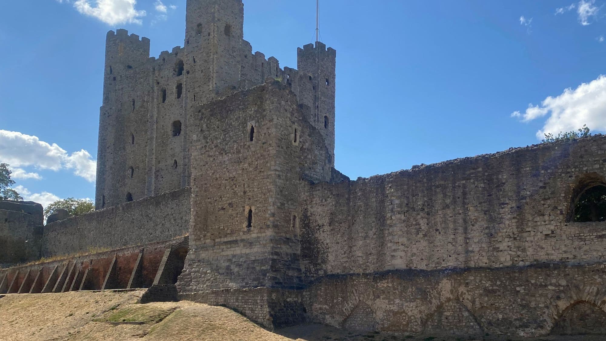 The Norman keep of Rochester Castle in Kent rising above the medieval walls and Boley Hill on a sunny day.