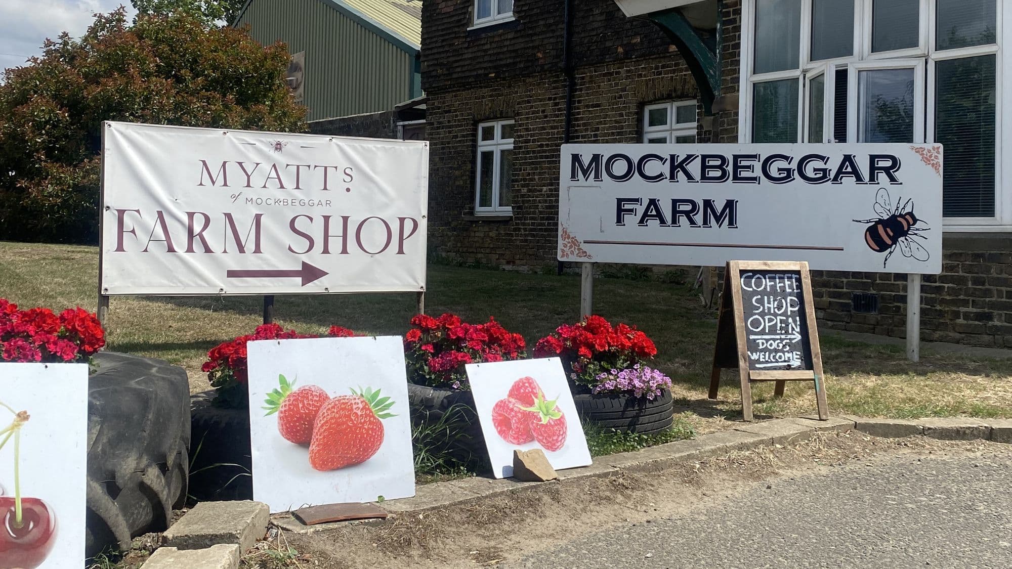 Entrance to Myatts of Mockbeggar Farm Shop near Cliffe Woods, with farm shop signs, flowers and seasonal fruit displays.