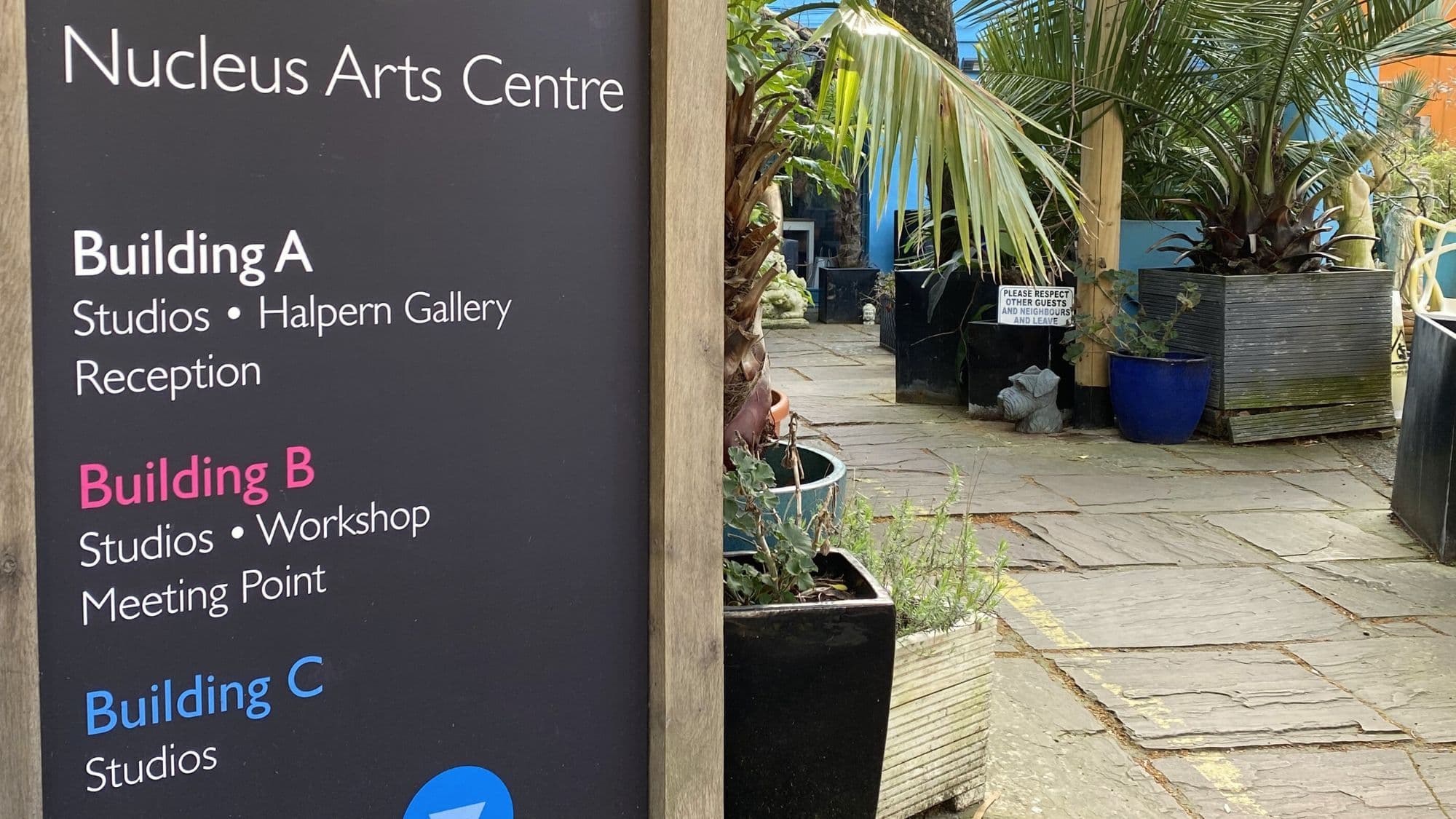 Entrance to Café Nucleus at Nucleus Arts Centre in Chatham, with courtyard path and plants beyond